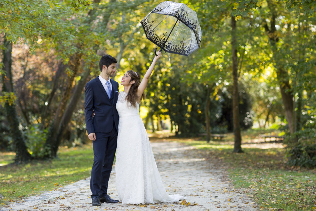 sebastien huruguen photographe mariage bordeaux couple de jeunes mariés avec une ombrelle lors de leur séance photo trash the dress au parc majolan de blanquefort